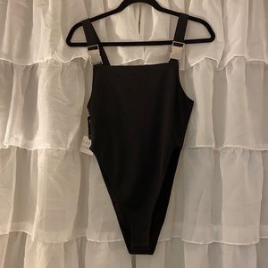 Caren Forbes black buckle body suit.